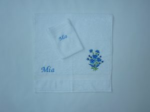 Witte handdoek en washand met bloem